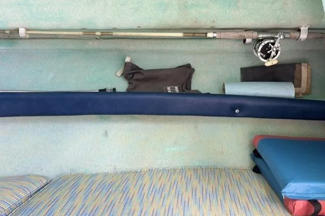 Slide: The Image of Interior of a 1989 Pursuit 2260 Denali boat with fishing gear and cushions. - 10