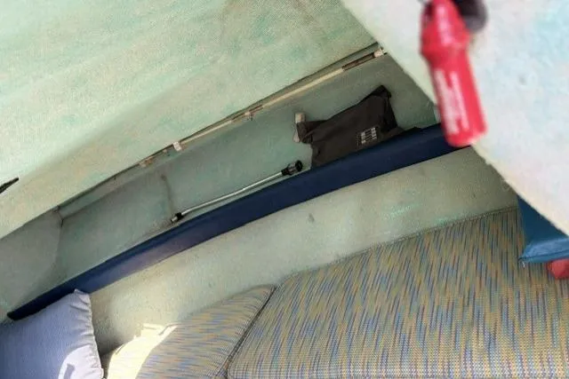Slide: The Image of Interior of a 1989 Pursuit 2260 Denali boat with cushions and storage. - 11