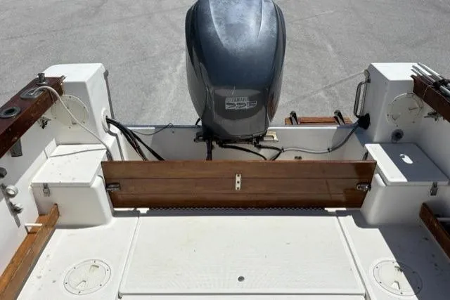 Slide: The Image of 1989 Pursuit 2260 Denali boat with outboard motor, spacious deck, and wooden accents. - 14