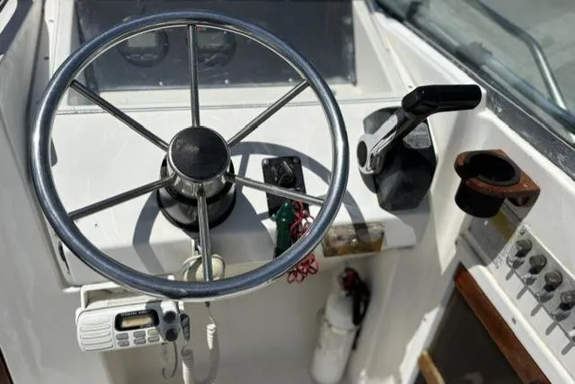 Slide: The Image of Steering console of a 1989 Pursuit 2260 Denali boat with controls and gauges. - 15