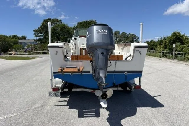 Slide: The Image of 1989 Pursuit 2260 Denali boat with 225 horsepower outboard motor, parked on a trailer. - 22