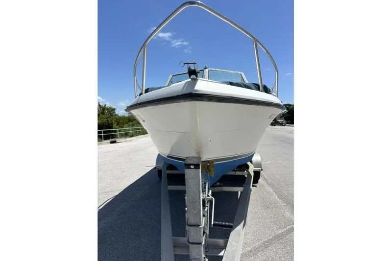 Slide: The Image of 1989 Pursuit 2260 Denali boat on trailer under clear blue sky. - 27