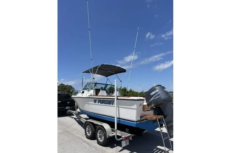 Slide: The Image of 1989 Pursuit 2260 Denali boat on trailer with Yamaha outboard motor under clear sky. - 3