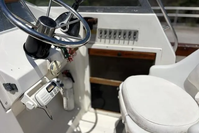 Slide: The Image of 1989 Pursuit 2260 Denali boat cockpit with steering wheel and control panel. - 6