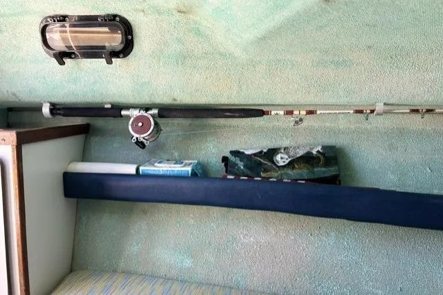 Slide: The Image of Interior of 1989 Pursuit 2260 Denali boat with fishing rod and supplies. - 8