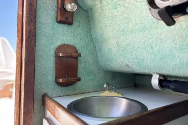 Slide: The Image of 1989 Pursuit 2260 Denali boat interior with sink and wooden fixtures. - 9