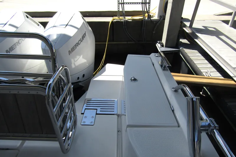 Slide: The Image of 2024 Nimbus Commuter 11 boat with dual Mercury engines at dockside. - 12