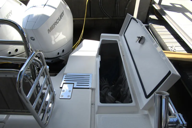 Slide: The Image of 2024 Nimbus Commuter 11 boat with Mercury engines and open storage compartment. - 13