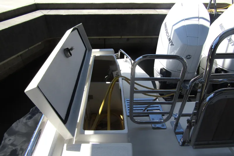Slide: The Image of 2024 Nimbus Commuter 11 boat with open storage compartment and Mercury outboard engines. - 15