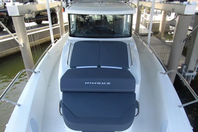 Slide: The Image of 2024 Nimbus Commuter 11 boat with cushioned deck, docked at marina. - 21