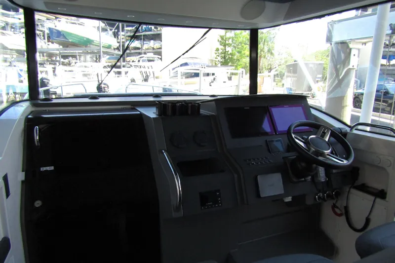 Slide: The Image of 2024 Nimbus Commuter 11 boat cockpit with modern steering and navigation controls. - 31