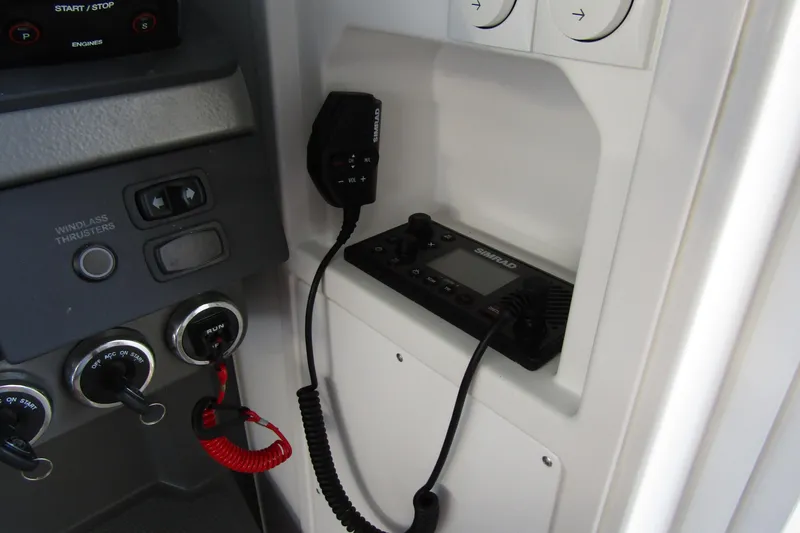 Slide: The Image of Control panel of 2024 Nimbus Commuter 11 with Simrad marine radio and switches. - 34