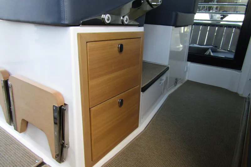 Slide: The Image of 2024 Nimbus Commuter 11 interior with wooden storage drawers and foldable table. - 40