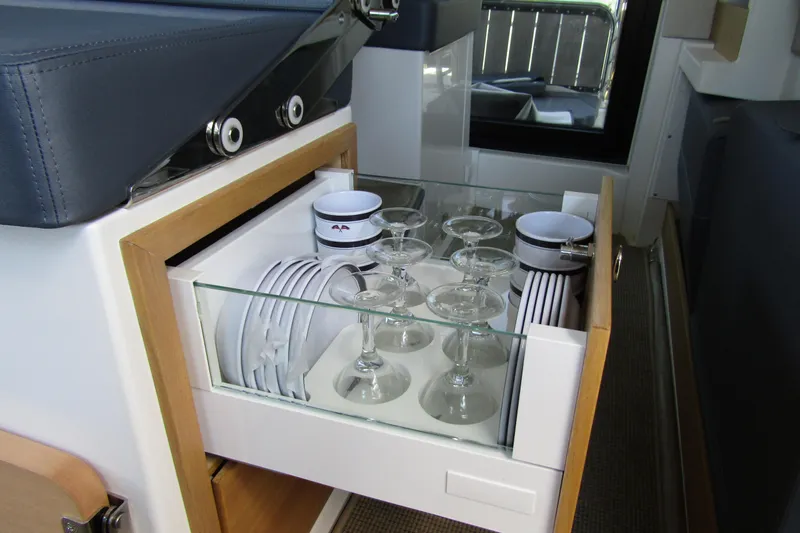 Slide: The Image of 2024 Nimbus Commuter 11 interior drawer with neatly arranged glassware and dishes. - 41
