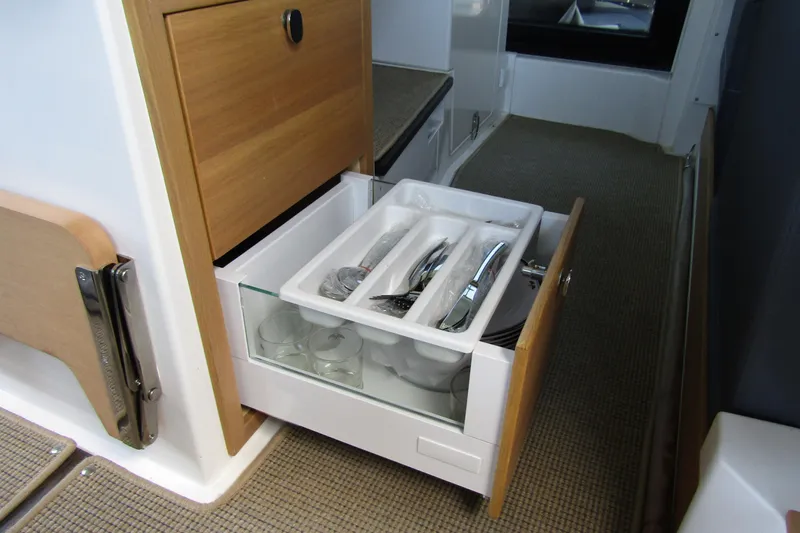 Slide: The Image of 2024 Nimbus Commuter 11 interior drawer with organized cutlery and glassware. - 42