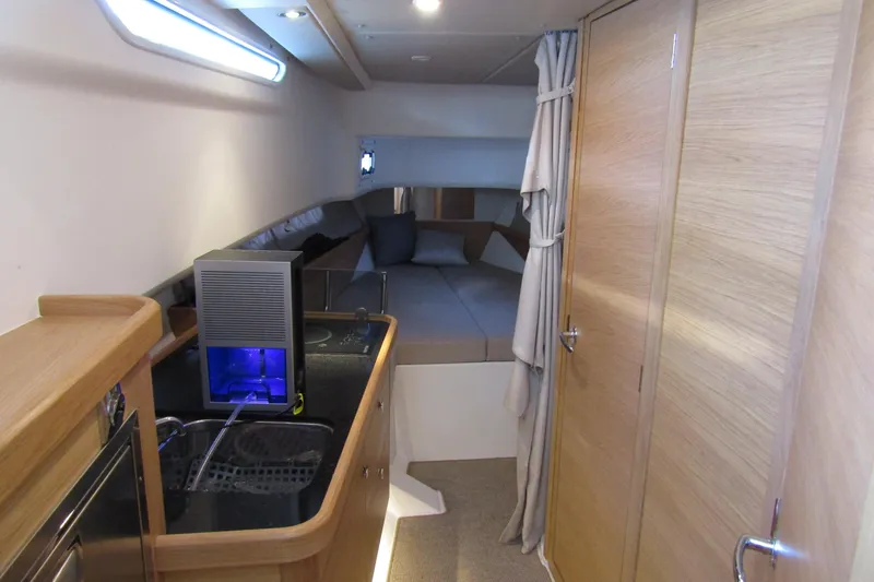 Slide: The Image of Interior of 2024 Nimbus Commuter 11 boat with modern kitchenette and cozy sleeping area. - 47