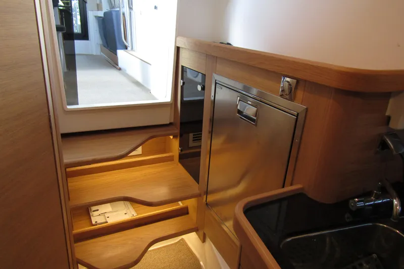 Slide: The Image of 2024 Nimbus Commuter 11 interior with wooden steps and stainless steel appliances. - 49