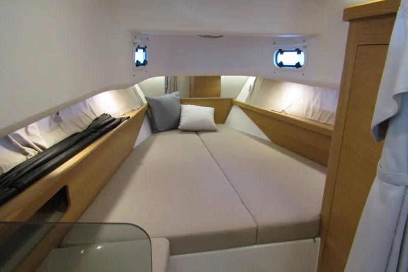 Slide: The Image of 2024 Nimbus Commuter 11 cabin interior with cozy bed and wooden accents. - 56