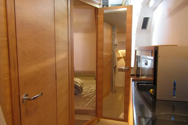 Slide: The Image of Interior of 2024 Nimbus Commuter 11, featuring wooden cabinetry and compact sleeping area. - 64