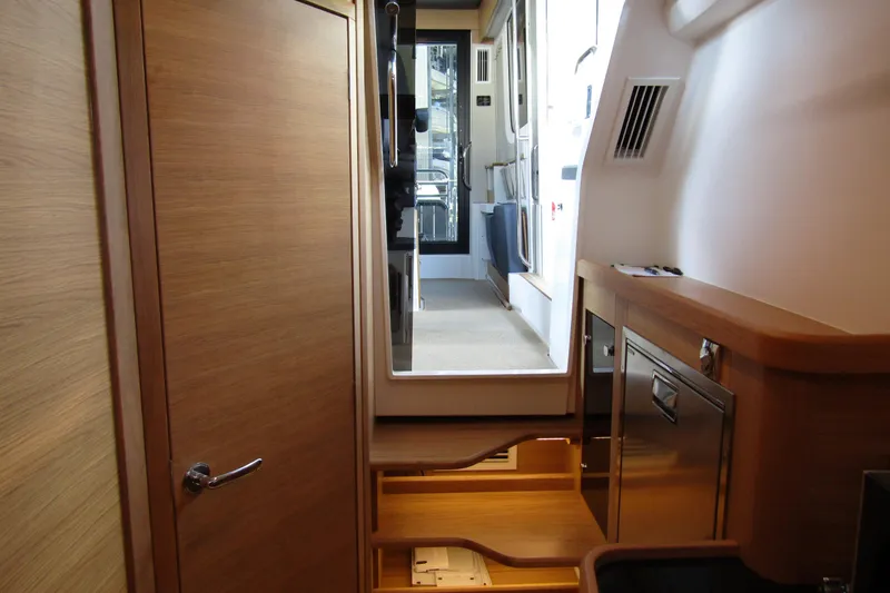 Slide: The Image of Interior of 2024 Nimbus Commuter 11 boat, featuring wooden cabinetry and modern design elements. - 67