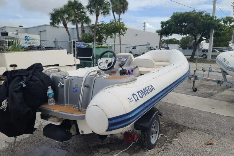 The Image of 2015 Williams 385 inflatable boat on trailer, parked outdoors near palm trees. - 1