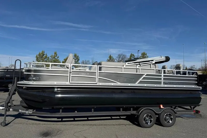The Image of 2024 Ranger Reata 220F pontoon boat on trailer under clear blue sky. - 0