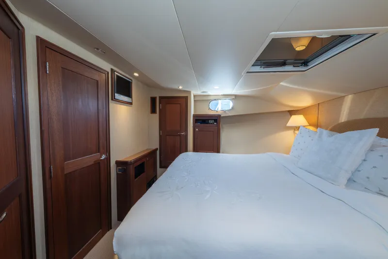 Slide: The Image of Luxurious 2007 Pacific Mariner Pilothouse yacht bedroom with elegant wood finishes and cozy bedding. - 22