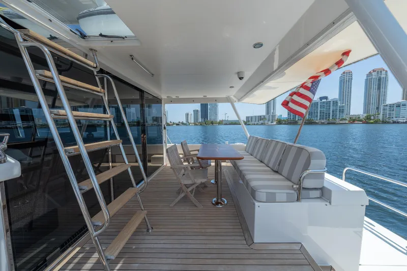 Slide: The Image of 2007 Pacific Mariner Pilothouse yacht deck with seating, table, and city skyline view. - 39