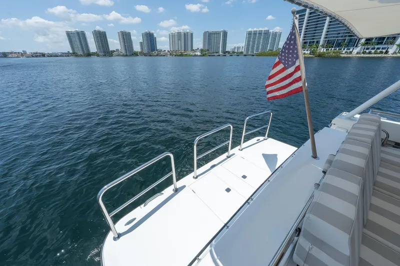 Slide: The Image of 2007 Pacific Mariner Pilothouse yacht with American flag, overlooking waterfront cityscape. - 40