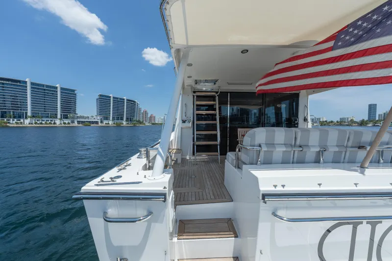Slide: The Image of 2007 Pacific Mariner Pilothouse yacht deck with American flag, overlooking waterfront cityscape. - 41