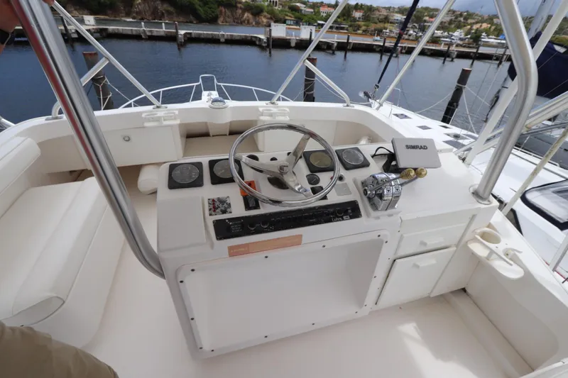 Slide: The Image of 2004 Luhrs 38 Convertible boat helm with steering wheel and navigation controls. - 16