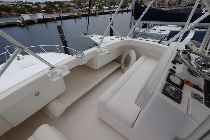 Slide: The Image of 2004 Luhrs 38 Convertible yacht cockpit with seating and steering wheel, docked at marina. - 18
