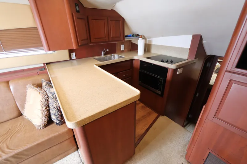 Slide: The Image of 2004 Luhrs 38 Convertible yacht interior with modern kitchen and cozy seating area. - 4