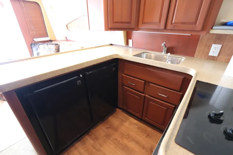 Slide: The Image of 2004 Luhrs 38 Convertible yacht kitchen with wood cabinets and modern appliances. - 5