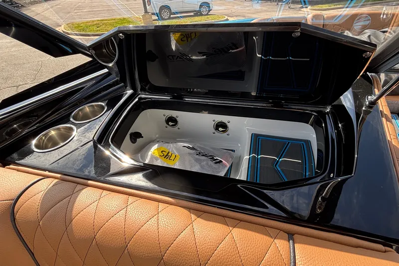 Slide: The Image of Open storage compartment in 2026 Tigé Z3 boat with cup holders and quilted seating. - 38