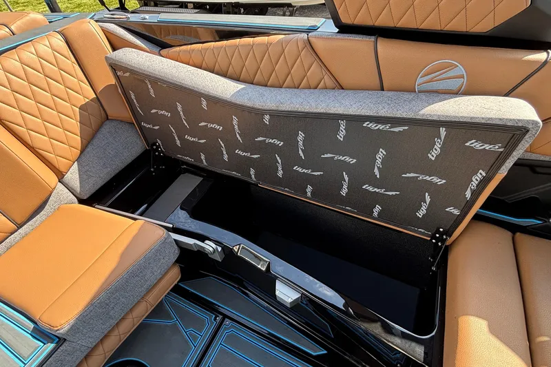 Slide: The Image of 2026 Tigé Z3 boat interior with open storage compartment, featuring luxurious tan and gray seating. - 57