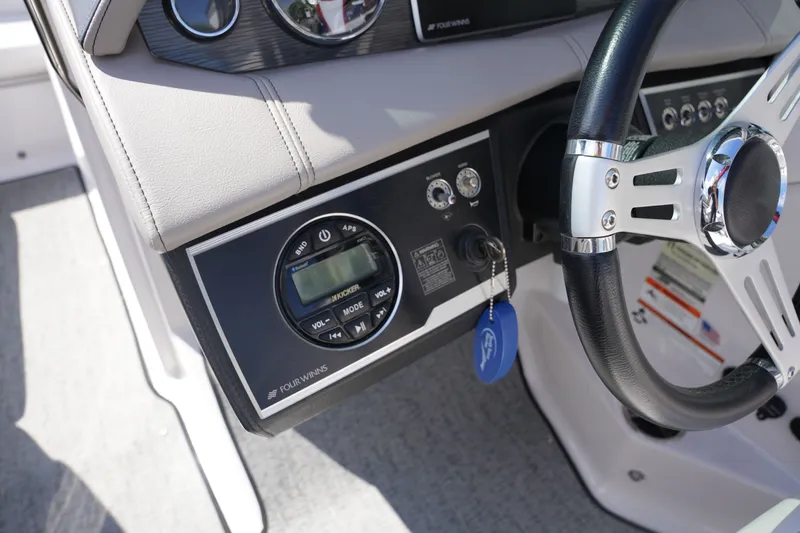Slide: The Image of Dashboard of a 2019 Four Winns H230 boat with steering wheel. - 29