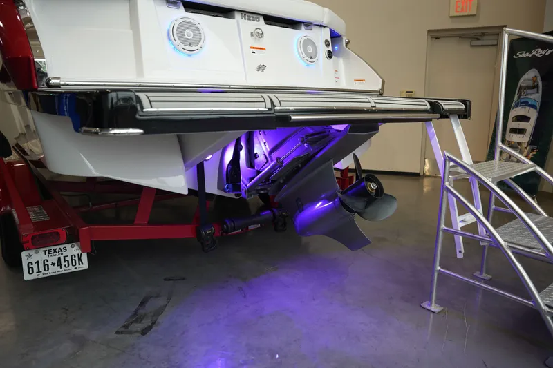 Slide: The Image of Rear view of a 2019 Four Winns H230 boat with purple lighting. - 8