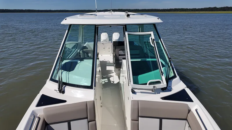 Slide: The Image of Boston Whaler 330 Vantage 2027 on calm water with spacious cockpit and comfortable seating. - 27