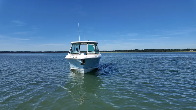 Slide: The Image of A 2027 Boston Whaler 330 Vantage on calm water under a clear sky. - 33