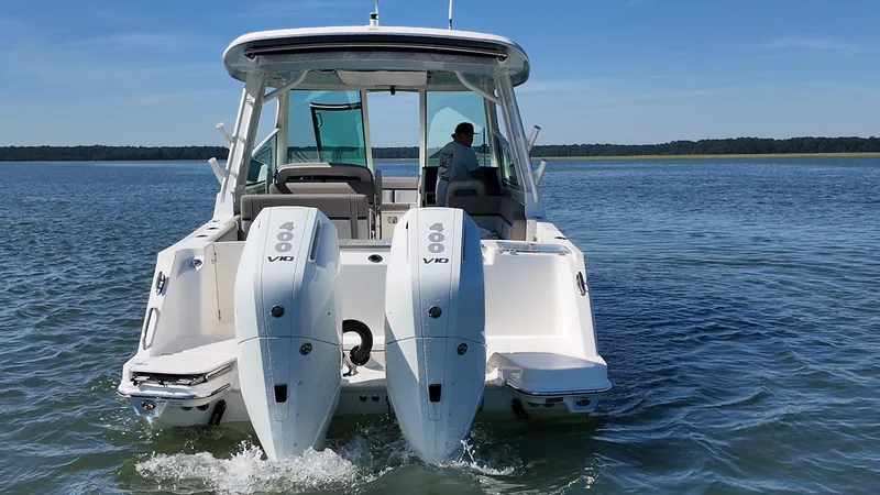 Slide: The Image of A 2027 Boston Whaler 330 Vantage with two large outboard engines on calm water. - 3