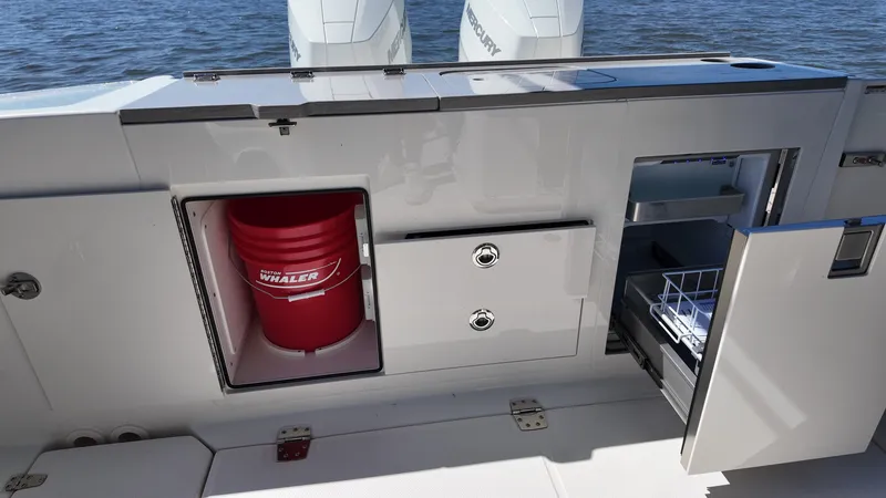Slide: The Image of The image shows the stern of a Boston Whaler 330 Vantage with storage and a refrigerator. - 9