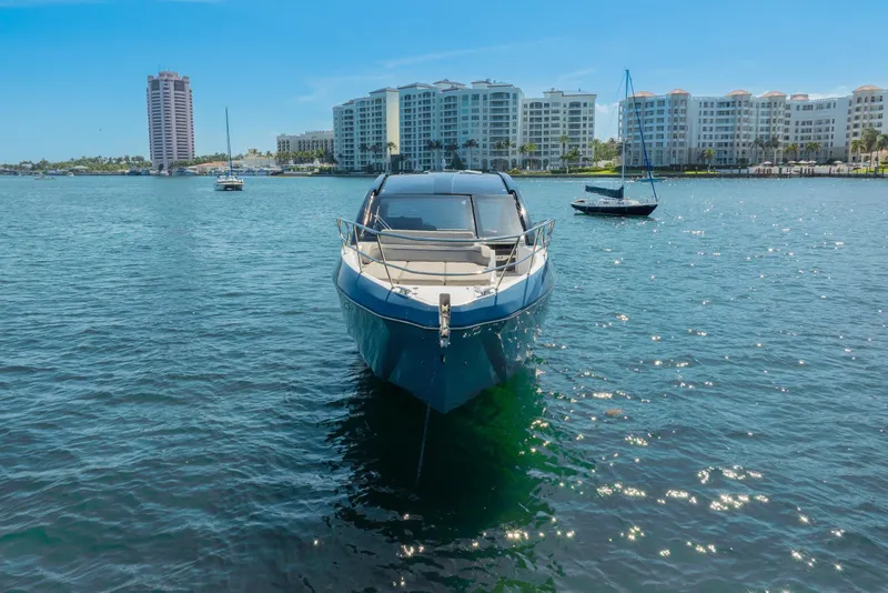 Slide: The Image of 2025 NX Boats NX41 HORIZON yacht on serene water with cityscape backdrop. - 11