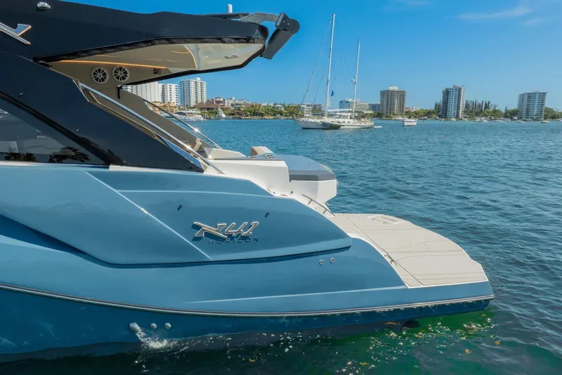 Slide: The Image of 2025 NX Boats NX41 HORIZON yacht docked in a scenic marina with city skyline. - 15