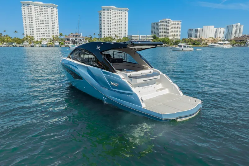 Slide: The Image of 2025 NX Boats NX41 HORIZON yacht on serene water with cityscape background. - 6