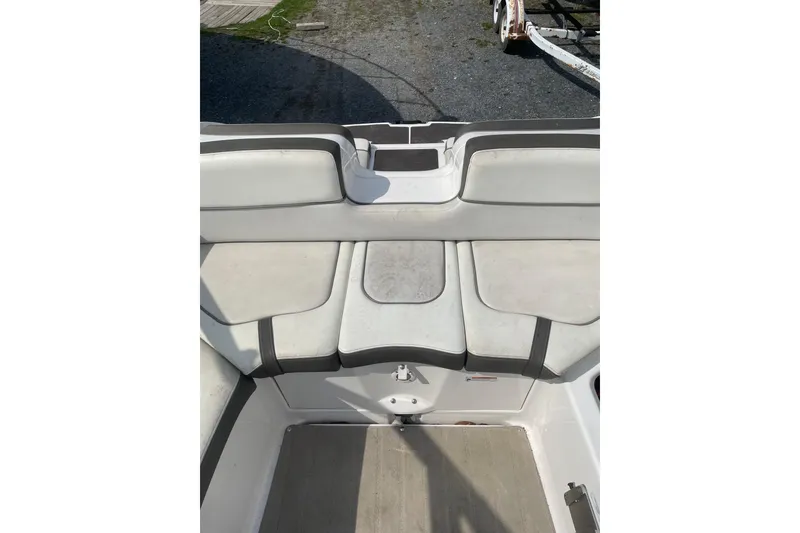 Slide: The Image of 2014 Yamaha Boats 242 Limited interior seating area with white and gray upholstery. - 10
