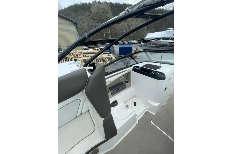 Slide: The Image of 2014 Yamaha Boats 242 Limited interior with seating and dashboard, docked outdoors. - 14