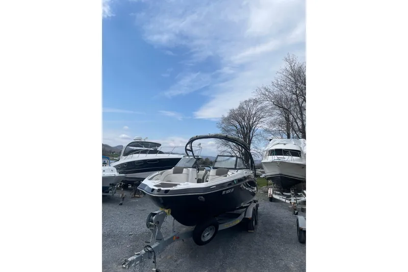 Slide: The Image of 2014 Yamaha Boats 242 Limited on trailer, parked outdoors under a clear sky. - 2