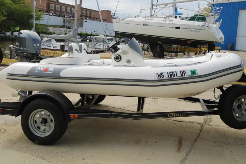 Slide: The Image of 2018 Avon Seasport 400 Deluxe NEO boat with 50hp engine on trailer, dockside. - 2