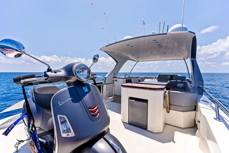 Slide: The Image of 2014 Lazzara 64 yacht with Vespa scooter on deck, cruising on open sea. - 29